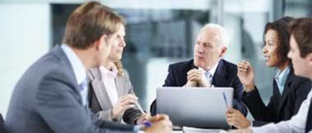 Business professionals in a meeting discussing audit and compliance strategies.
